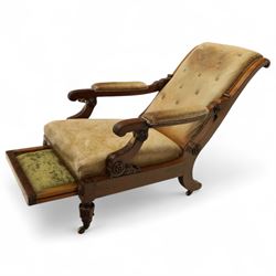 William IV mahogany gentleman's library reclining armchair, leather button upholstered and brass-studded back and seat, above leather-covered arms terminating with carved roundels and foliate scroll-carved ends, underside with brass mechanical trigger reclining lever, the apron with retractable foot rest, supported on lappet carved and turned legs with brass castors, circa 1835