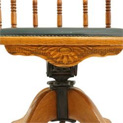 Edwardian oak captains swivel desk chair of tub form, shaped cresting rail over spindle supports and green-leather upholstered seat, foliate apron over swivel action and four-spoke base