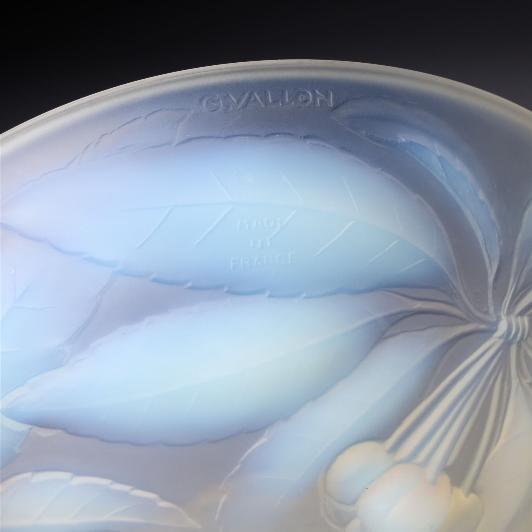 G Vallon, a French opalescent glass bowl decorated with a raised pattern of cherries and leaves signed G Vallon D23cm