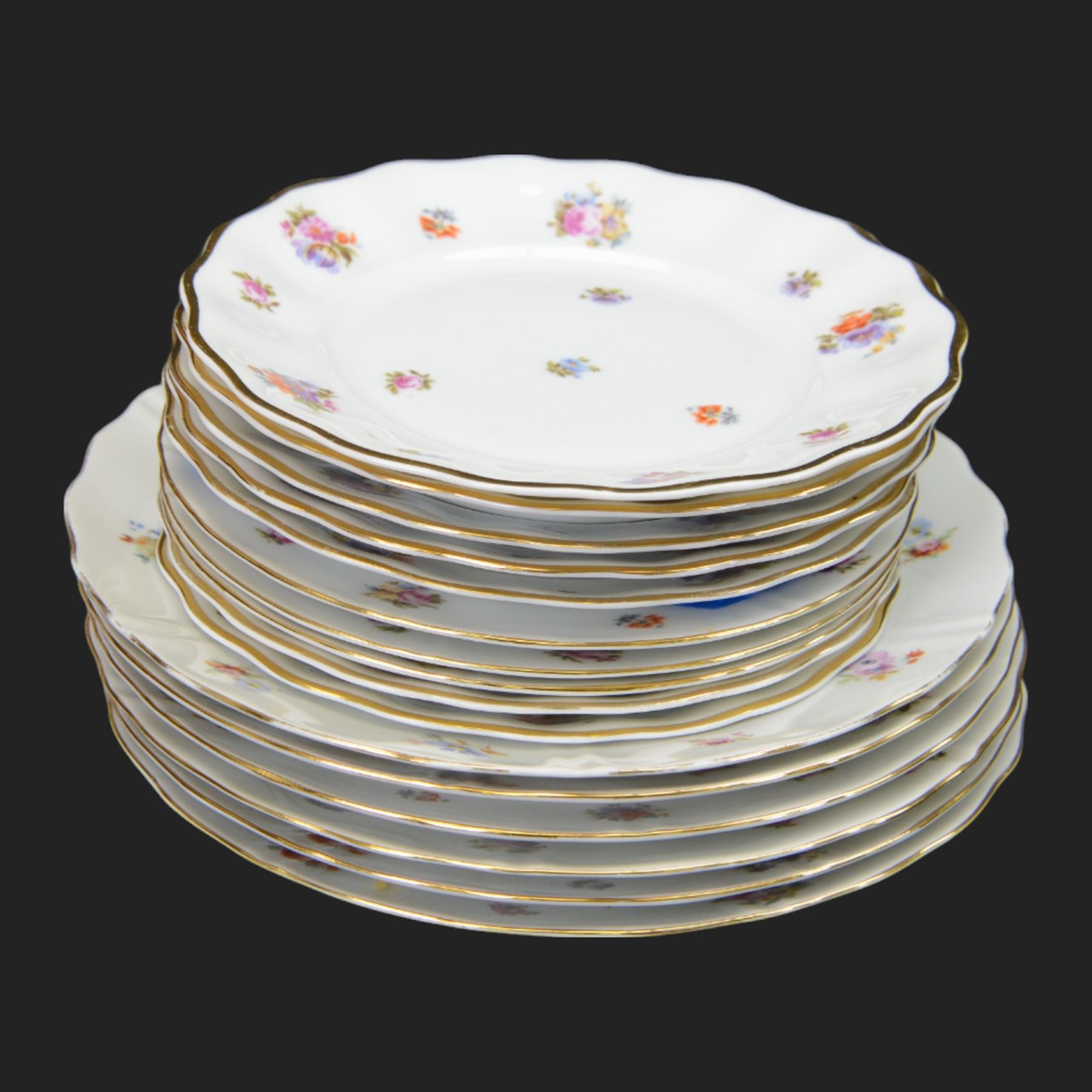 Forstenberg part tea and dinner service, comprising teapot, teacups and saucers, dinner plates, tureens, sauce boat, lidded sugar bowl, side plates and serving plates, all decorated with polychrome floral sprigs on a white ground with gilt edging