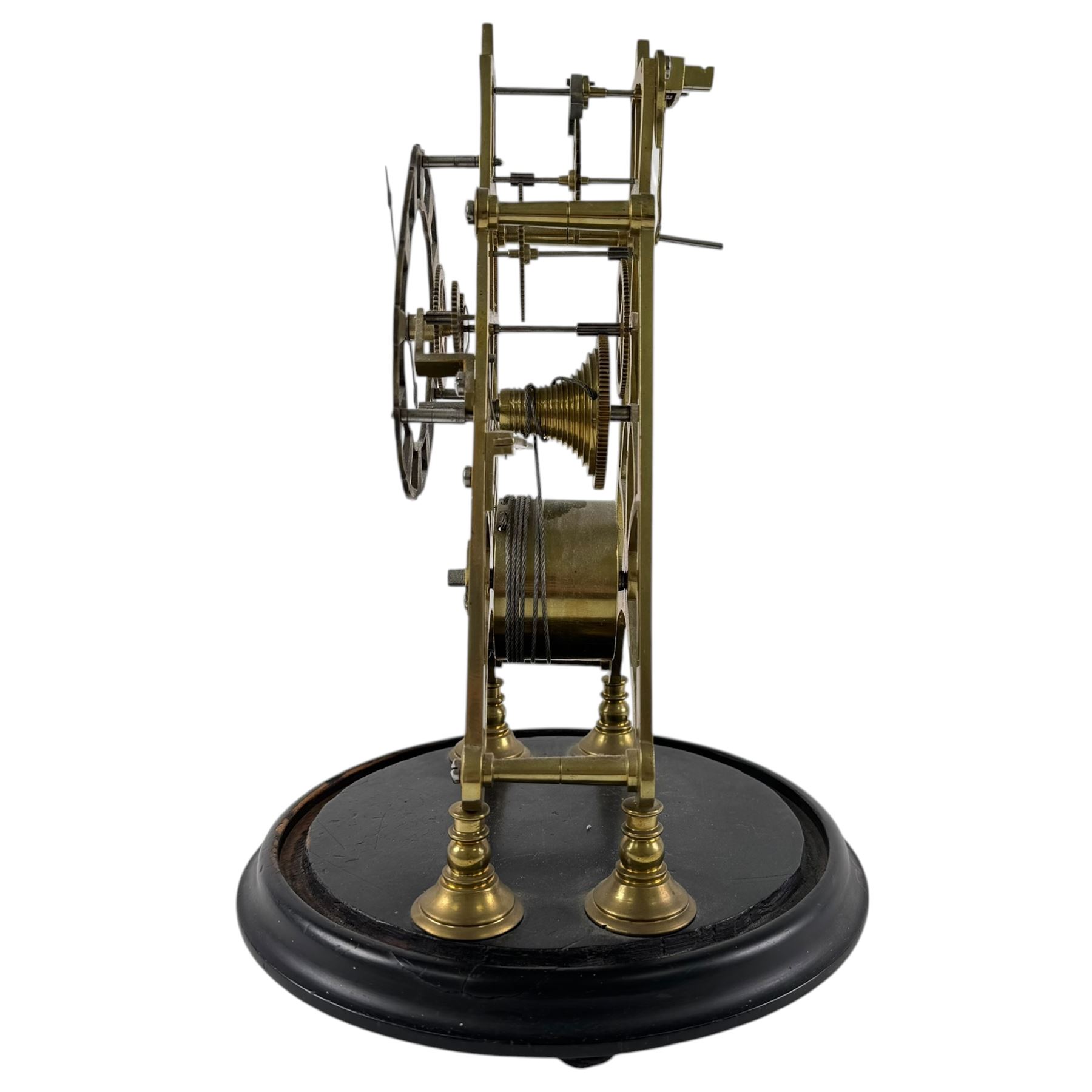 Brass skeleton clock, the single fusee movement with silvered Roman numeral dial, upon an ebonised circular base, missing the glass dome, H32cm