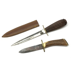 Fighting knife with 15cm steel double edged blade, one edge serrated, brass crosspiece and reeded hardwood grip, in leather sheath L27cm overall; and a hunting dagger, the 10cm single edged blade marked H.G. Long Sheffield, brass crosspiece and antler grip (2)