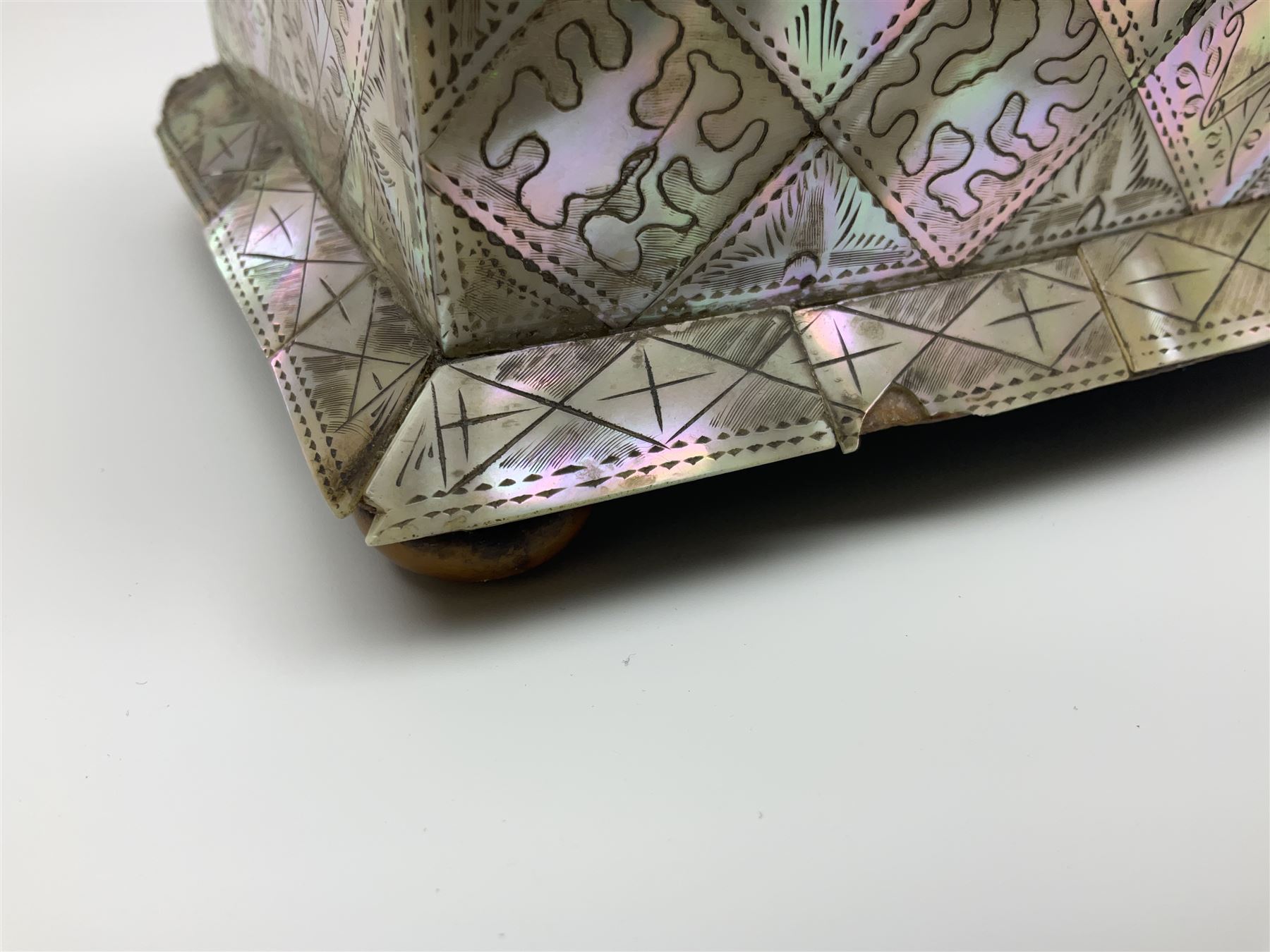 Victorian mother of pearl tea caddy, of rectangular bow-fronted form, the body with floral, bird and geometric engraved mother of pearl panels, white metal shield plaque to the cover inscribed with the initials G.J.A and similar escutcheon, the two division interior with ivory edging and two panelled mother of pearl lids, on four vegetable ivory bun feet L20cm, together with a similar style mother of pearl card case (2) This item has been registered for sale under Section 10 of the APHA Ivory Act