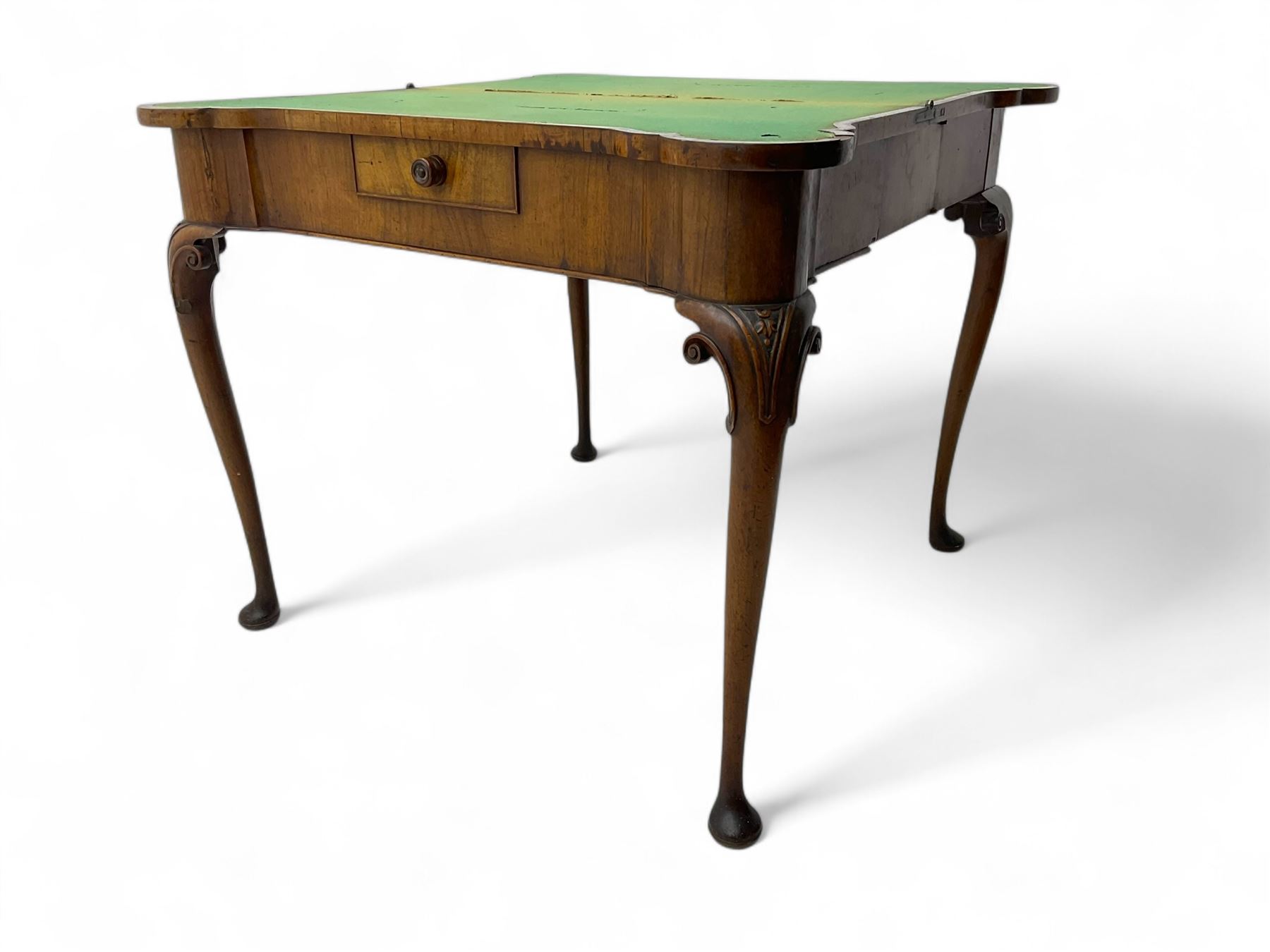 Georgian walnut fold-over card table, shaped rectangular top opening to reveal a baize-lined surface, supported by a concertina pull-out rear mechanism, frieze fitted with single drawer, raised on cabriole supports with foliate carvings terminating in pad feet