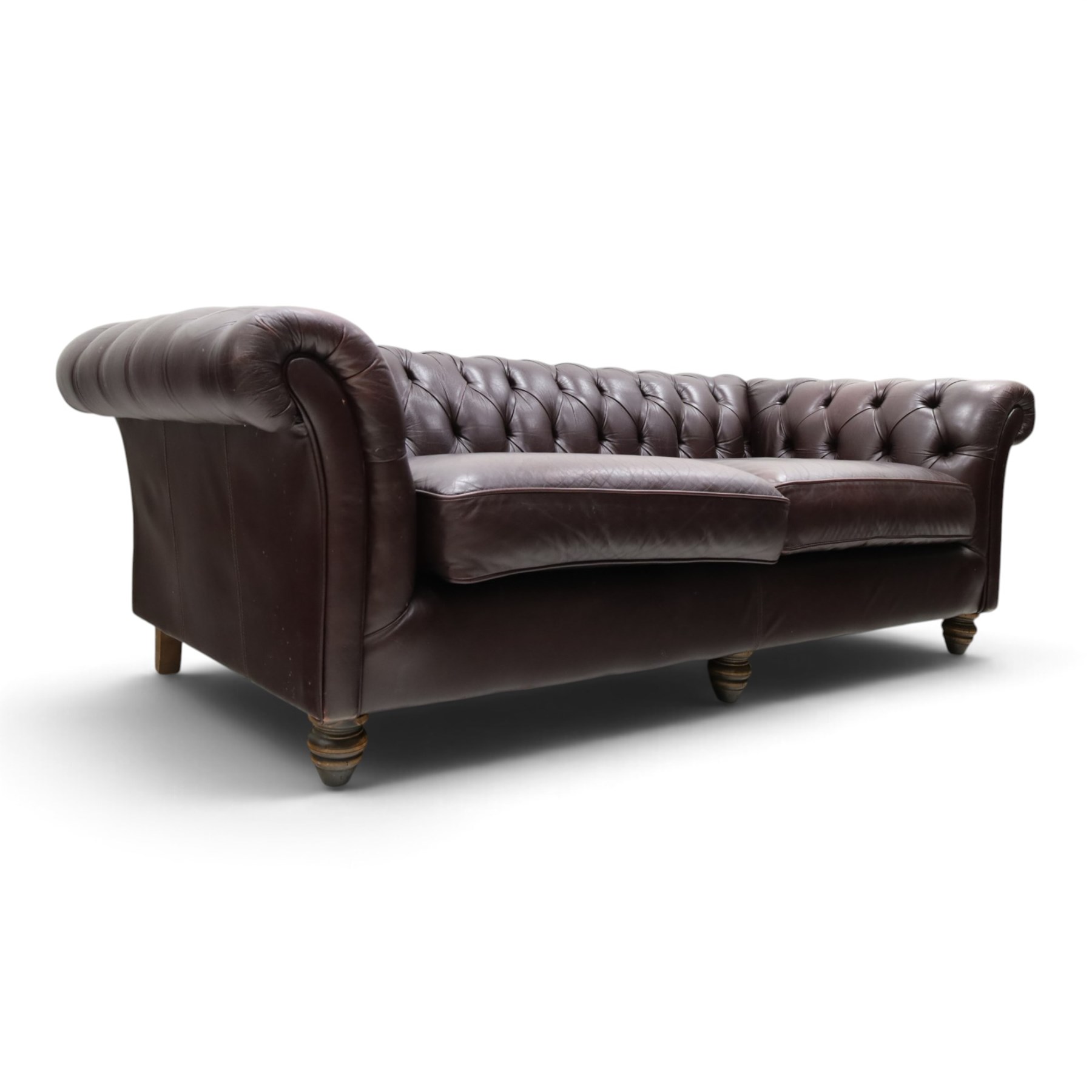 Thomas Lloyd - traditional shape Chesterfield two seater settee with rolled back and arms, upholstered in buttoned deep oxblood leather with loose seat cushions, raised on turned feet