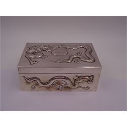Late 19th century/early 20th century Chinese export silver mounted cigarette box, of rectangular form, decorated in relief with dragons, the hinged cover with similar dragon decoration and central blank oval cartouche, opening to reveal a softwood lined compartmentalised interior, stamped beneath with character mark and KMS for maker Kwong Man Shing, H6.3cm, W15.5cm, D9.5cm
