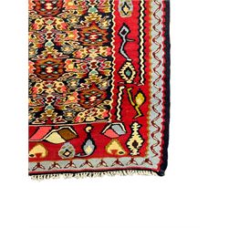 Senneh Kilim crimson ground rug, decorated with stylised plant motifs within overlapped lozenges, the border decorated with stylised motifs, within light blue guard stripe 