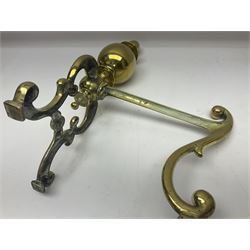 Pair of early 20th century brass fire dogs, each with sphere and urn finial, upon a scrolling base, H38cm