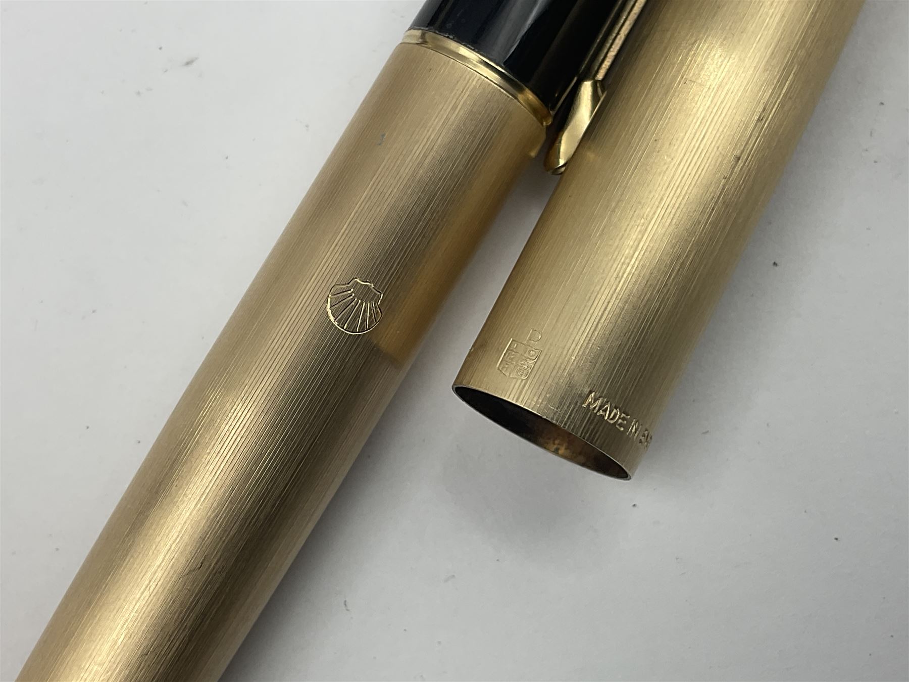 Three rolled gold Parker fountain pens, comprising an example with a gold nib marked 14K 585 and barrel with a shell stamp, a Parker 61 fountain pen with inset gold arrow to the nib, and another similar, all with striated decoration and arrow clips to the caps, L13cm, one with box