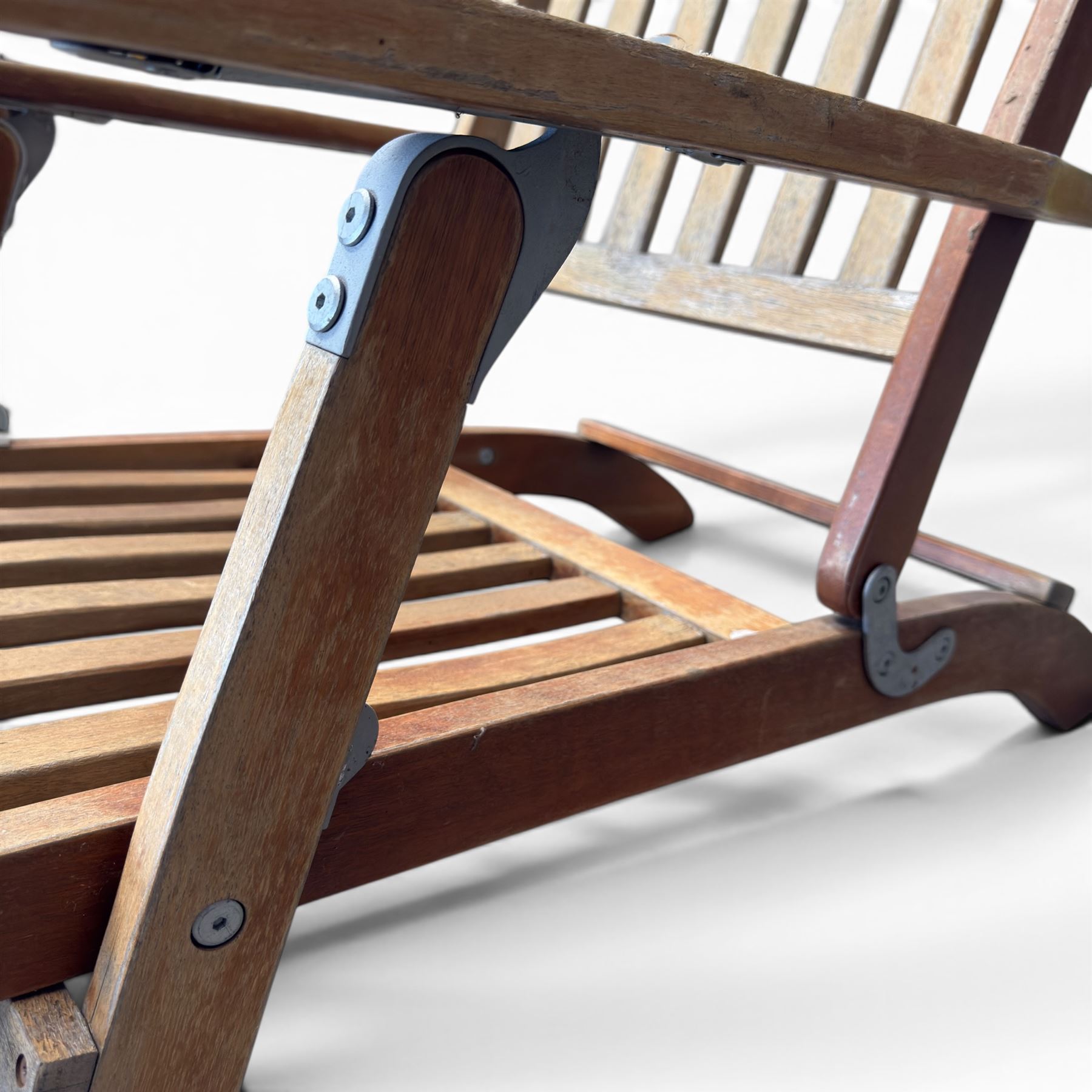 Pair of teak folding steamer chairs, with slatted backs, seats and extending footrests, adjustable recline.