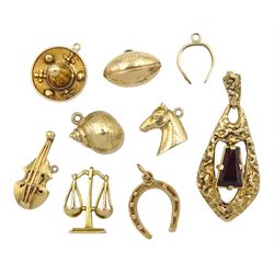 Two 17ct gold charms including sombrero and violin, five 9ct gold charms including shell, Libra scales, rugby ball, horses head and horseshoes and a 9ct gold garnet pendant