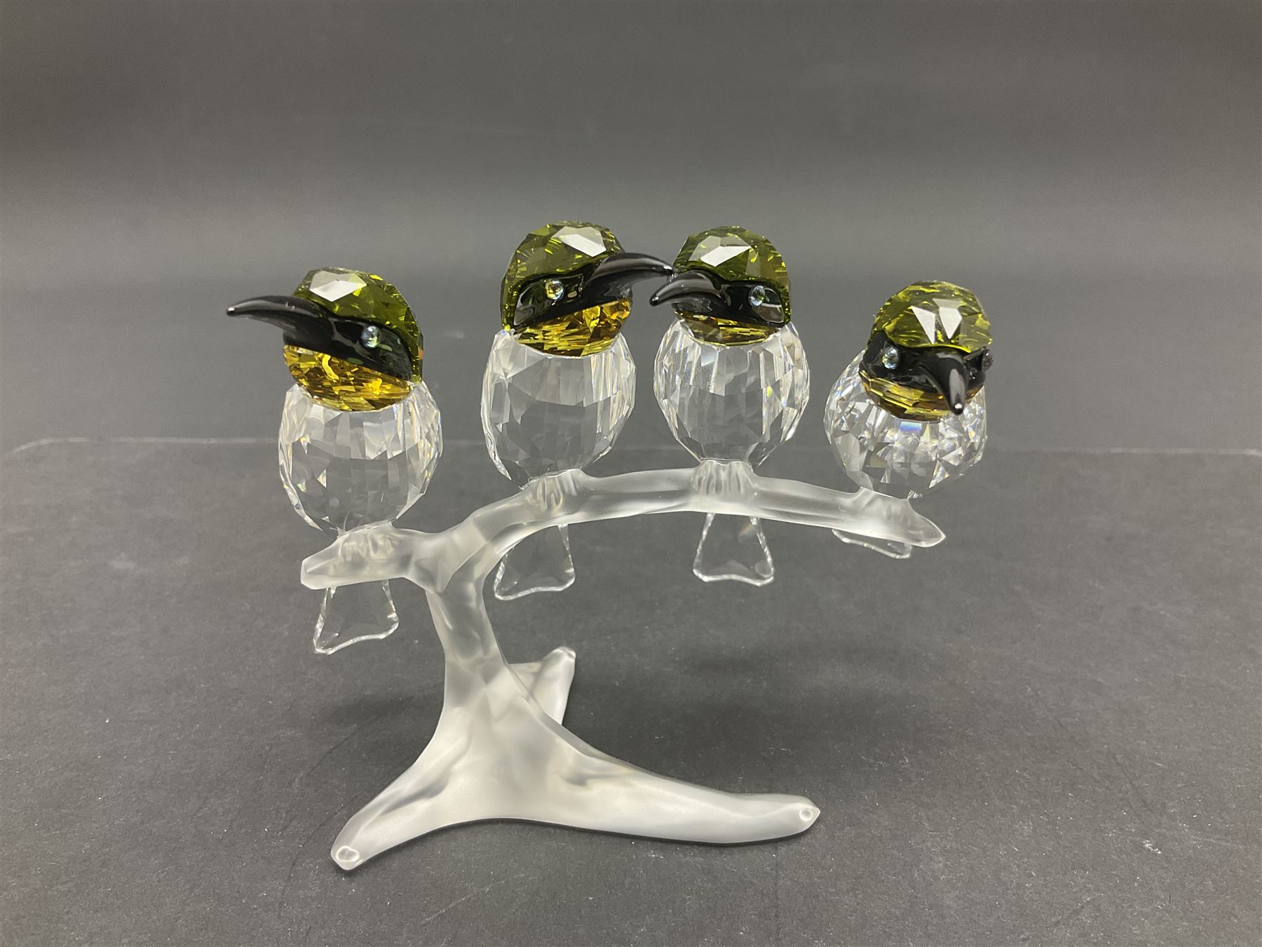Four Swarovski Crystal bird figures, comprising Cockatoo, pair of Hoopoes on a branch, four Lovebirds on a branch and four Hummingbirds on a branch, largest H10cm