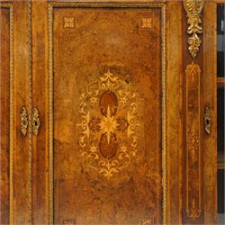 Large fine Victorian figured and burr walnut credenza, the breakfront D-shaped top with moulded edge, over an ornate frieze with inlaid Aesthetic Movement scrolling and geometric ornament, applied with gilt-metal ribbon-twist moulding and mounts, the central panelled doors profusely inlaid with scrolling foliate motifs and stringing, flanked by gilt-metal cartouche and scrolling acanthus corbel mounts, with flanking glazed bow-front side doors, on skirted base with further gilt metal foliate mounts