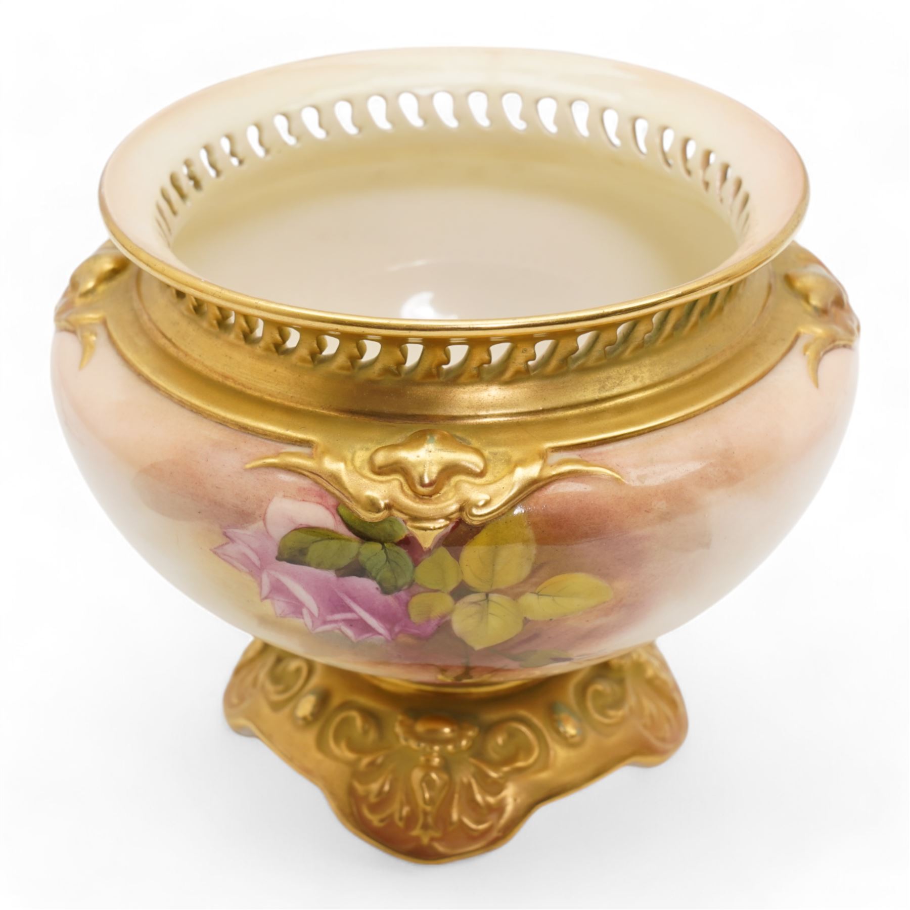 1920s Royal Worcester porcelain rose bowl, the flattened baluster body hand painted with roses and foliage, below a flared gilt pierced border, raised upon scroll moulded quatrefoil foot, shape no. H166, H13cm, together with a similarly decorated Royal Worcester bowl (2)