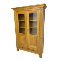 Oak display cabinet, enclosed by two panelled and glazed doors and fitted with two drawers, three internal shelves