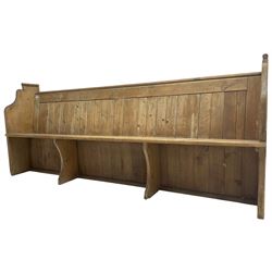 Early 20th century pine church pew, vertical plank back over rectangular seat, flanked by shaped end supports, with bible rest to back