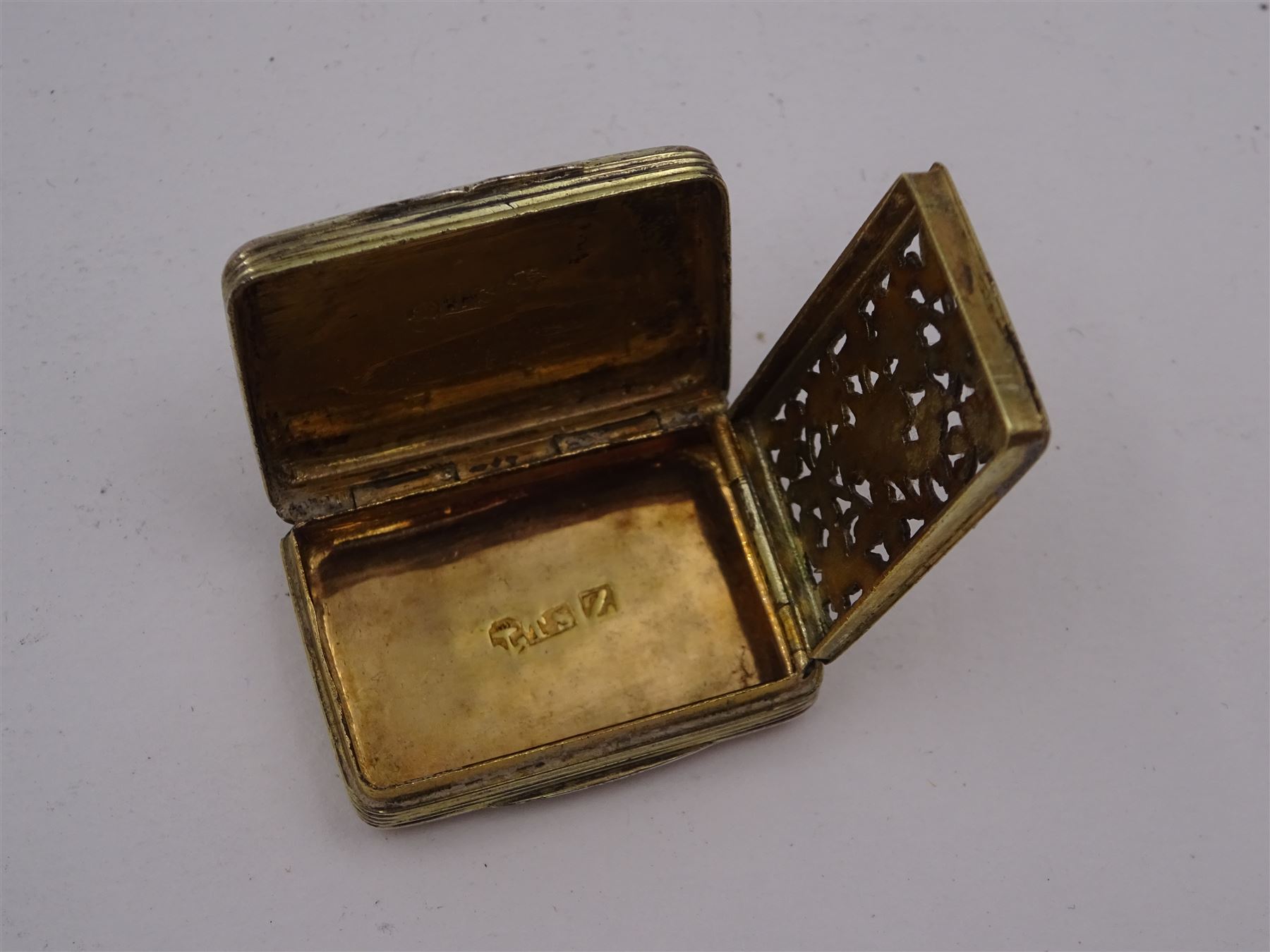 George III silver vinaigrette, of typical rectangular form, with raised foliate rim and engine turned decoration, with banded sides and foliate pierced engraving to gilt interior, hallmarked Birmingham 1797, maker's mark TS, L3cm