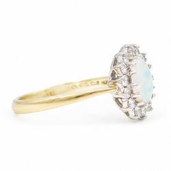 18ct gold opal and diamond cluster ring, single oval cabochon cut opal, surrounded by fourteen round brilliant cut diamonds, London 1988, total diamond weight approx 0.30 carat