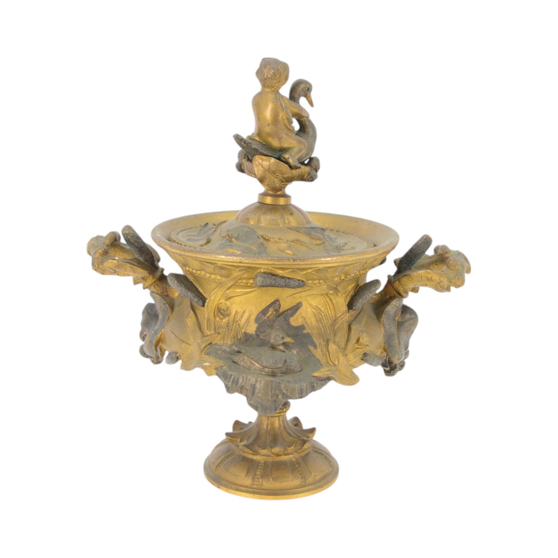 19th century gilt bronze twin handled urn, the removable cover with foliate decoration and finial modelled with a putti and swan, the body decorated in relief with swans and reeds, upon a circular foot, H19cm
