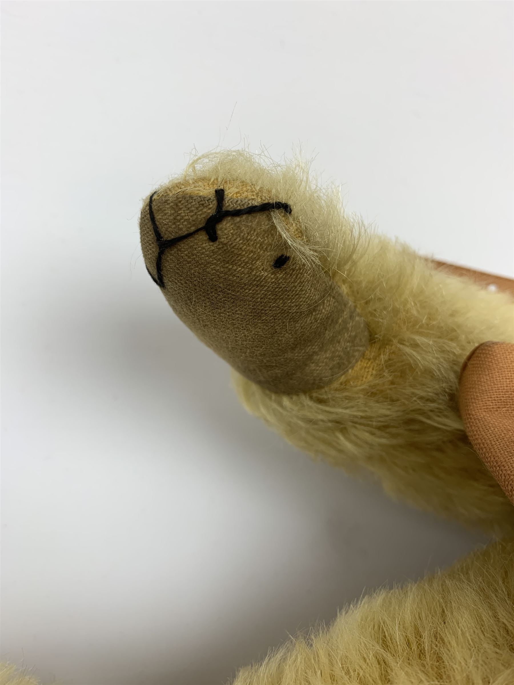 Merrythought Hygienic Toys large 'Magnet' teddy bear c1930s with plush body, swivel jointed head with glass eyes and vertically stitched nose and mouth and jointed limbs,  celluloid wishbone button to right ear and stitched label under right pad H22