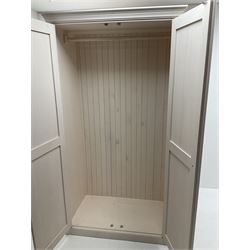 White finish double wardrobe, projecting cornice, two panelled cupboard doors enclosing fitted interior, platform base 