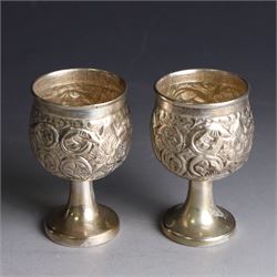 Pair of miniature Indian silver goblets, with embossed floral and foliate decoration, H6.5cm