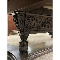 Large 19th century carved oak library table, the rectangular top with lunette carved edge over cartouche panelled and carved  scroll frieze, the central tapering rectangular support relief carved with masks and garlands, on four carved seated lion supports at each corner, on flat angular stretcher with recessed castors stamped ‘Bartholomew & Fletcher, London’
