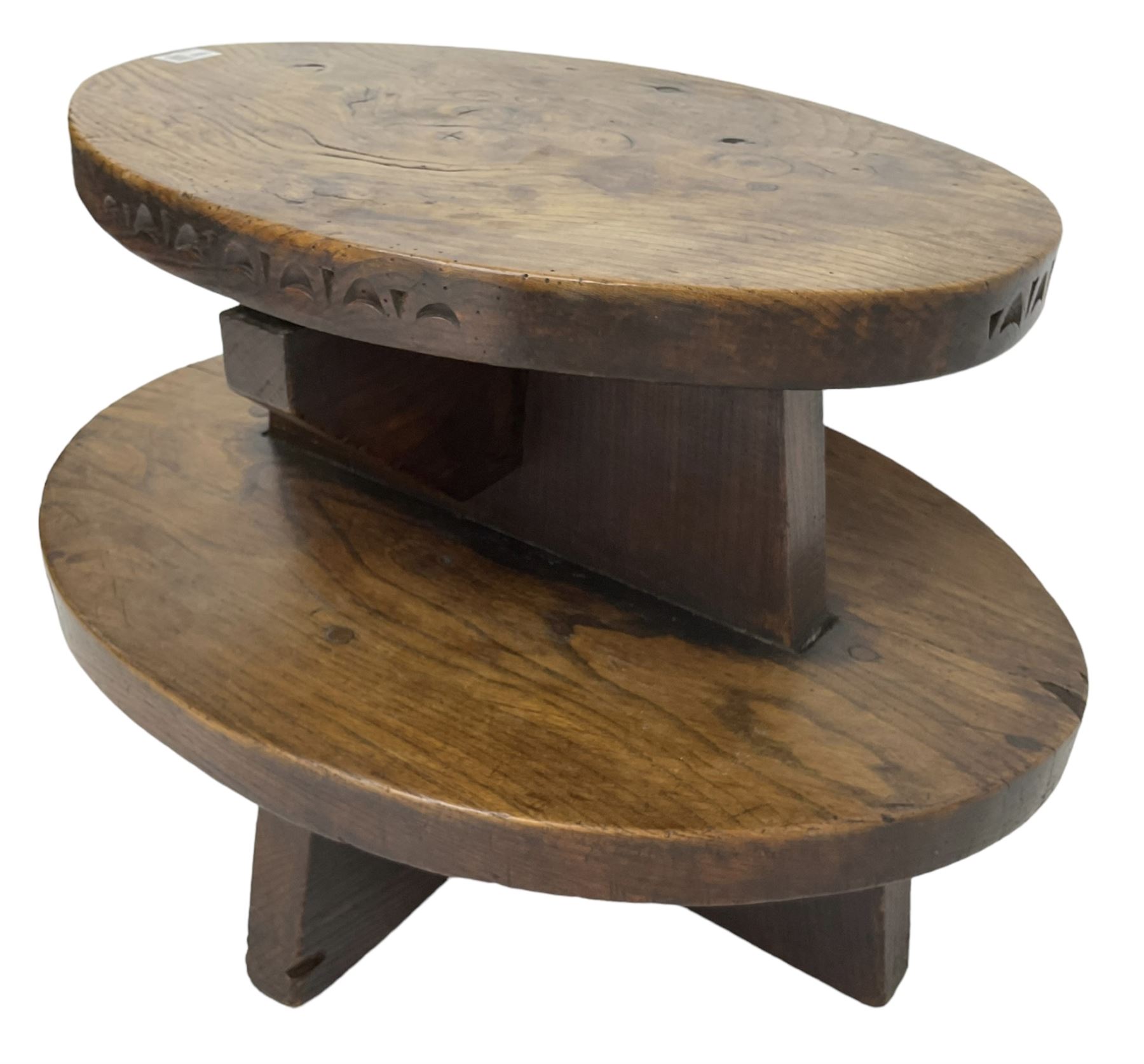 20th century figured elm occasional table, two oval tiers raised on cruciform base, the top tier carved with incised decoration 