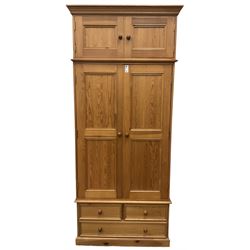 Solid pine double wardrobe, fitted with top box, enclosed by panelled doors, two short and one long drawer, on plinth base 