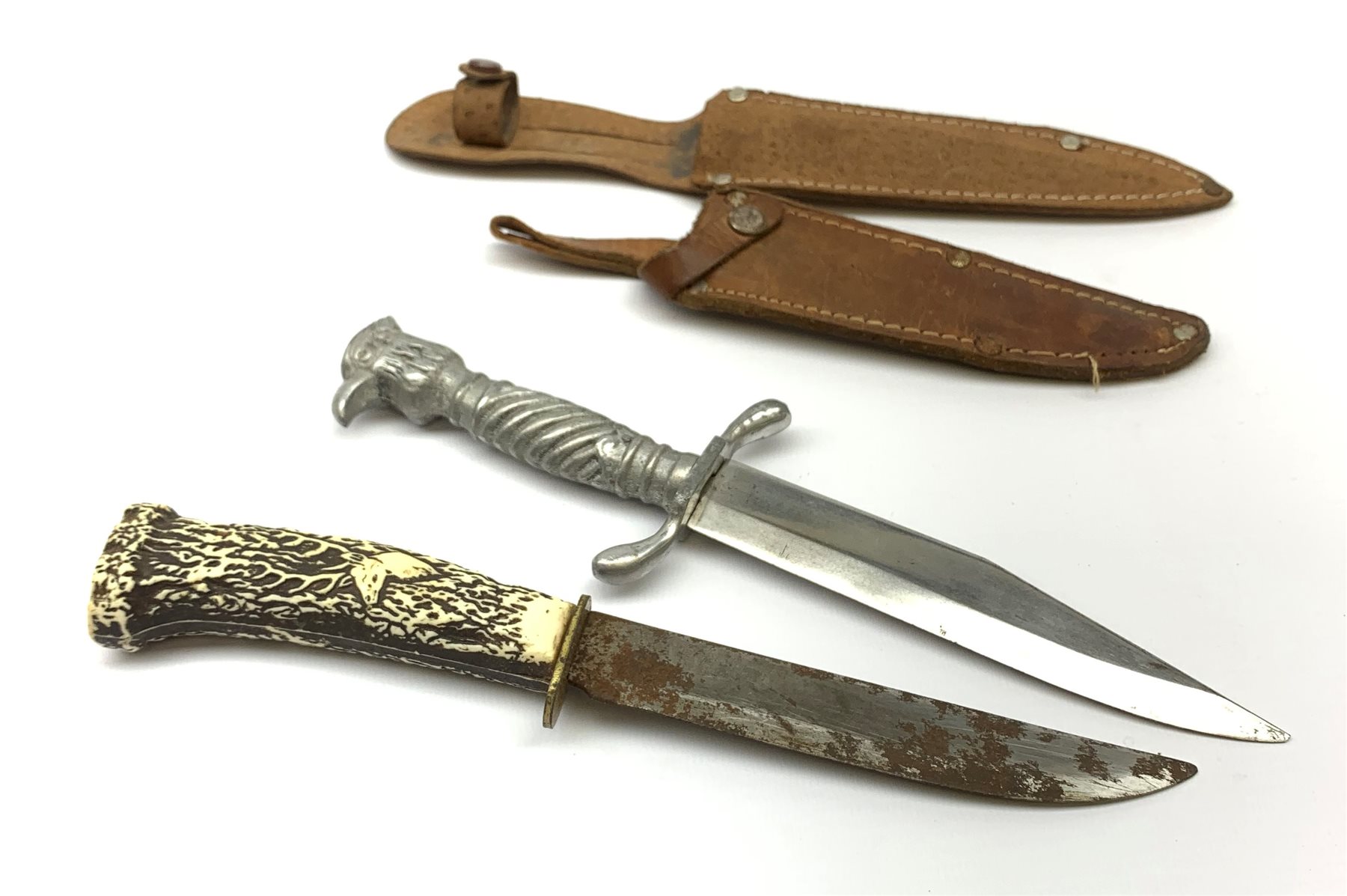 20th century hunting knife with 13cm single edge blade, cast white metal hilt with S-shaped quillon, wrythen grip and eagle head pommel L25cm overall; and another hunting knife with Solingen 12cm blade and simulated stag antler grip, both in leather sheath (2)