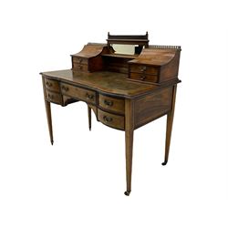 Late Victorian rosewood Carlton House type writing desk, raised bevelled mirror back flanked by two curved compartments with drawers, inlaid with urns, linen swags and scrolling foliate, the moulded top fitted with tooled leather inset over five drawers, square tapering supports with brass cups and castors
