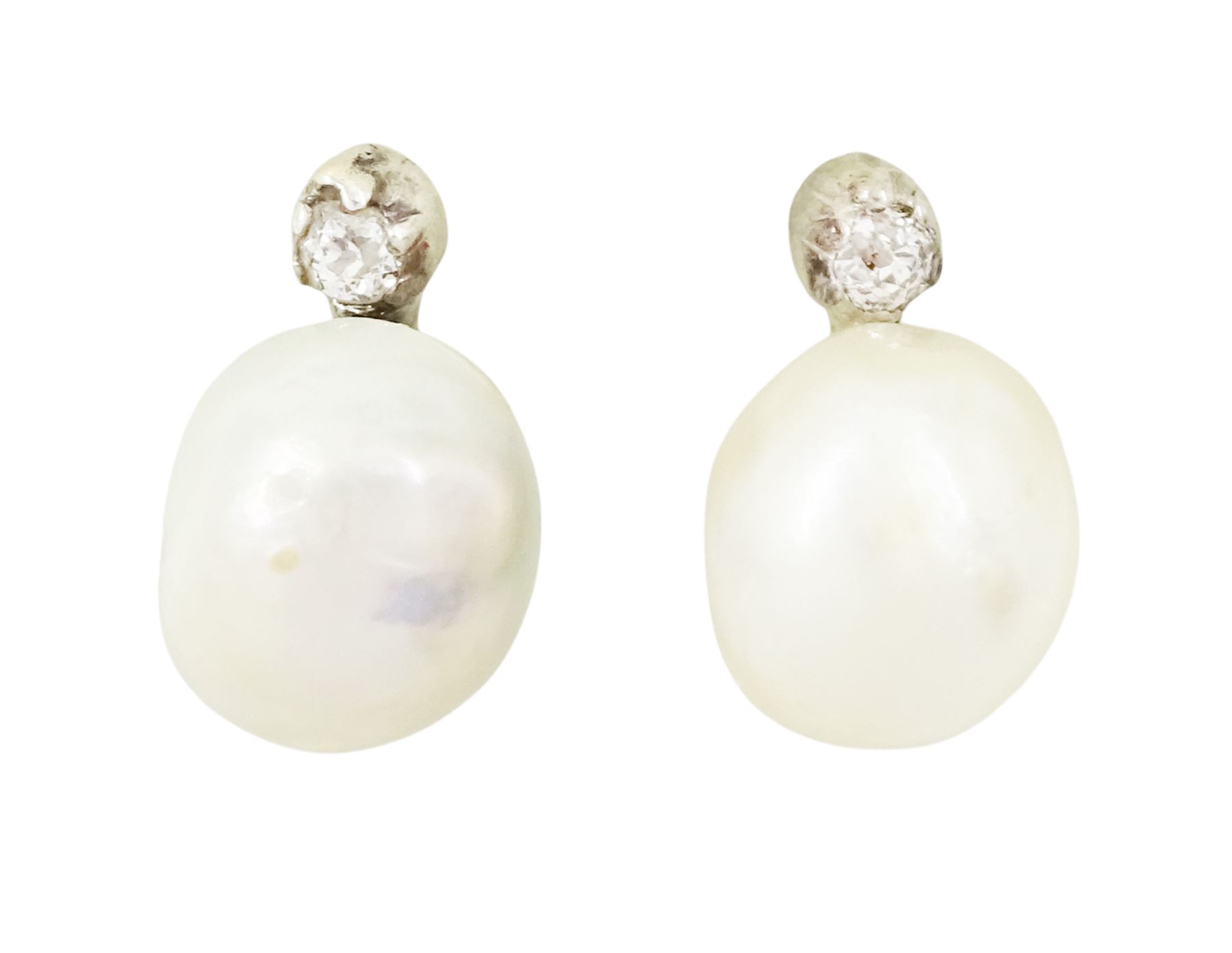 Pair of 19th / early 20th century natural saltwater pearl and diamond earrings, one stud set with a single white / cream pearl, the other with a white / grey / cream pearl, each suspending from a single old cut diamond, total pearl weight approx 4.30 carat