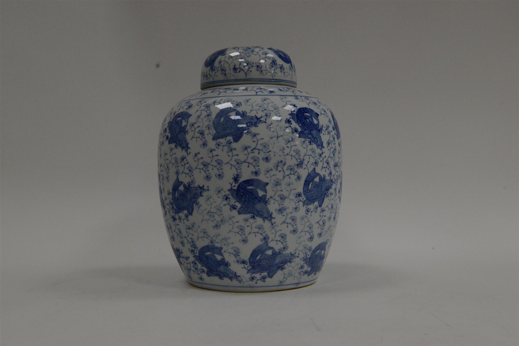 Blue and white ginger jar, decorated in a repetitive pattern of fish swimming amongst dense clusters of aquatic foliage, H40cm