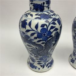 Pair of late 19th/early 20th century Chinese blue and white vases, each of baluster form, painted with dragons amidst flowers, each with Kangxi character marks beneath, H14cm 