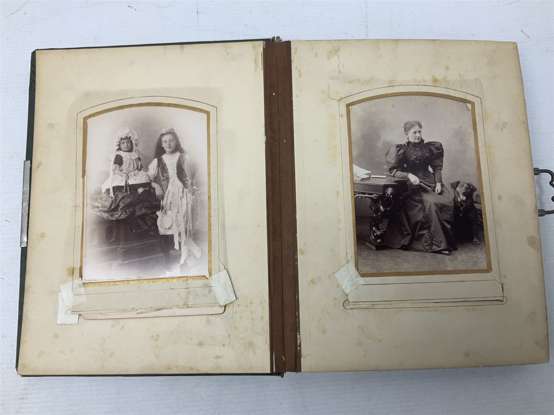 Victorian desk ink blotter, decorated with painted spray of flowers within stylised gilt rococo spandrels with mother of pearl fixings, together with a Victorian photo album containing interior leaves with apertures of various sizes and shapes of portraits surrounded by printed sea and dock scenes, blotter L28cm