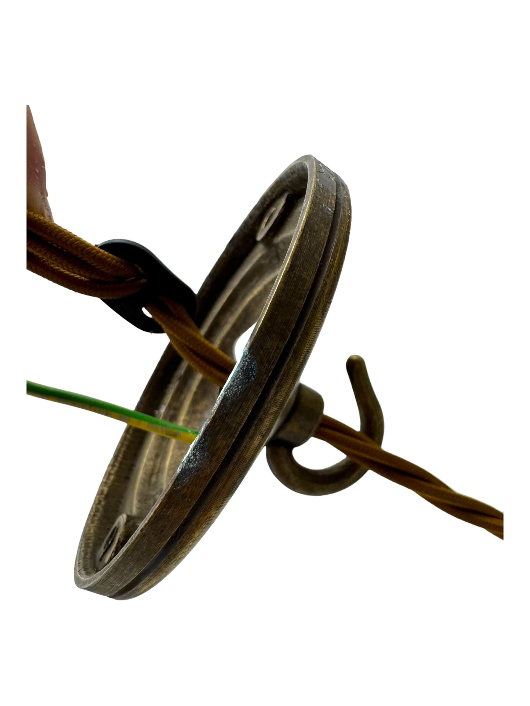 Set of two small and two large pendant lights, each with clear glass spherical shade with moulded swirl pattern, suspended from twisted cords, brass ceiling rose