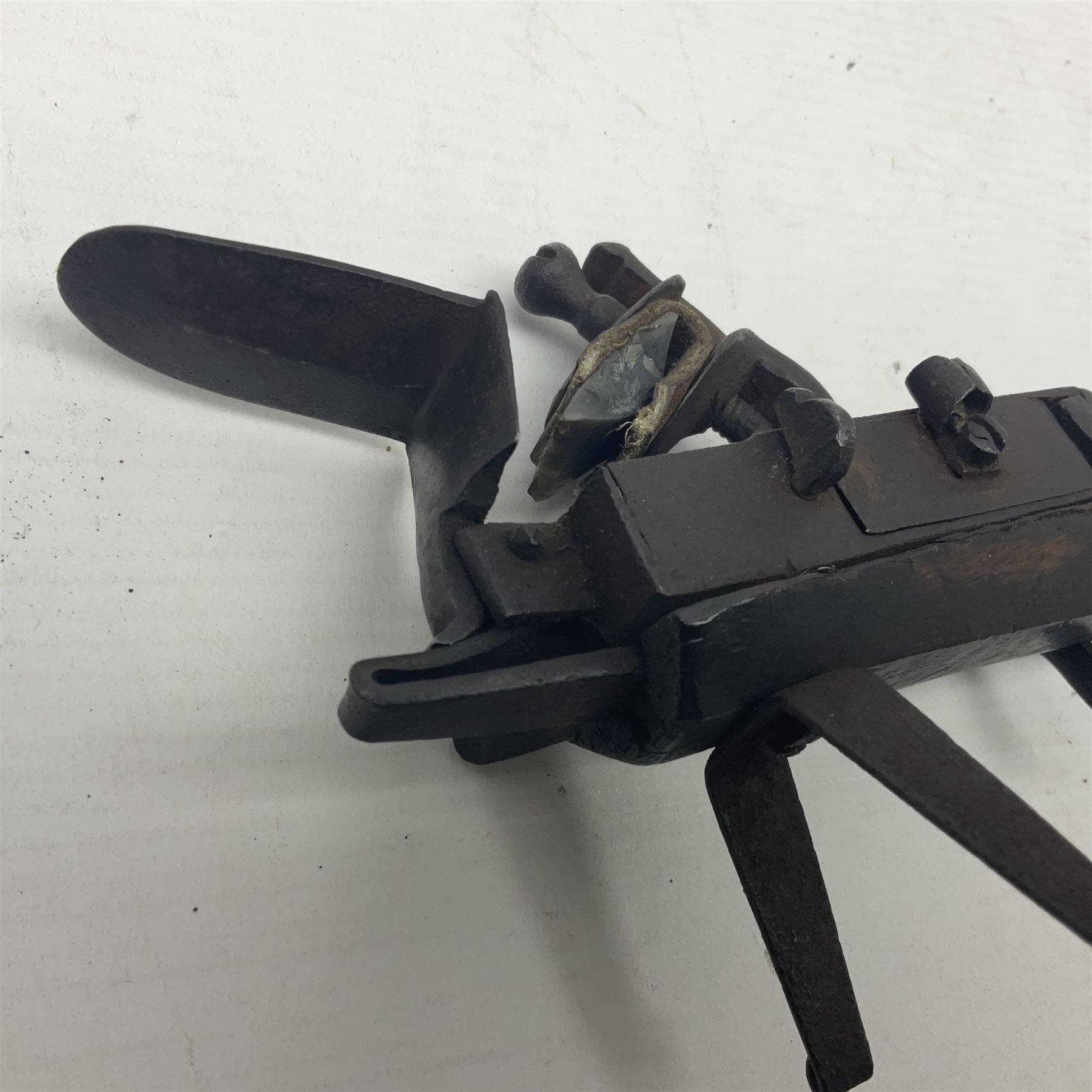 Late 18th/early 19th century flintlock tinder lighter, the steel box lock with hinged door to the left side, fruitwood butt with plain bar trigger, the left side set with a taper sconce and bipod front support, L21cm.