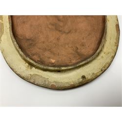 Pair of 19th century classical terracotta relief wall plaques depicting the goddess Hygeia and another goddess, seated holding an ewer, each of oval form, indistinctly signed, each stamped Ferreira verso, H42cm, W30cm