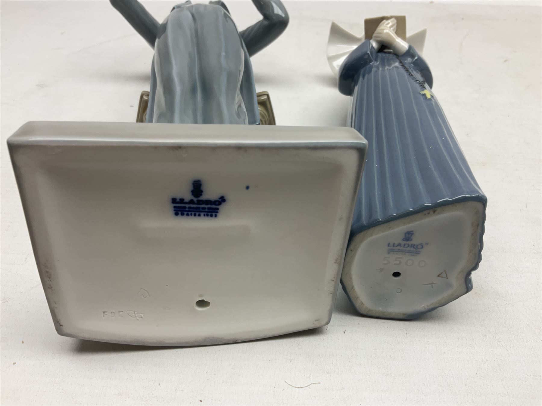 Two Lladro figures, comprising Conductor no 5196 and Prayerful Moment no 5500 together with a Lladro plaque and two Lladro candle holders, Dolphins at Play no 17666 and Sailing the Seas no 17665, all with original boxes, largest example H33cm 