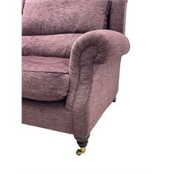 Parker Knoll - pair of large two-seat sofas upholstered in purple fabric, turned mahogany finish front feet with brass cups and castors 