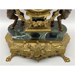 20th century continental gilt metal Lyre mantle clock on a raised plinth with paw feet and variegated green marble base, with two bronzed metal figures of mythological cherubs with animal legs and cloven hooves holding a festooned garland swag, surmounted by a marble urn and finial, eight-day twin barrel Hermle striking movement with a floating lever balance, striking the hours and half-hours on two bells, white enamel dial with roman numerals, minute track and serpentine steel hands, with a cast brass bezel and bevelled convex glass, dial inscribed “Imperial”.


