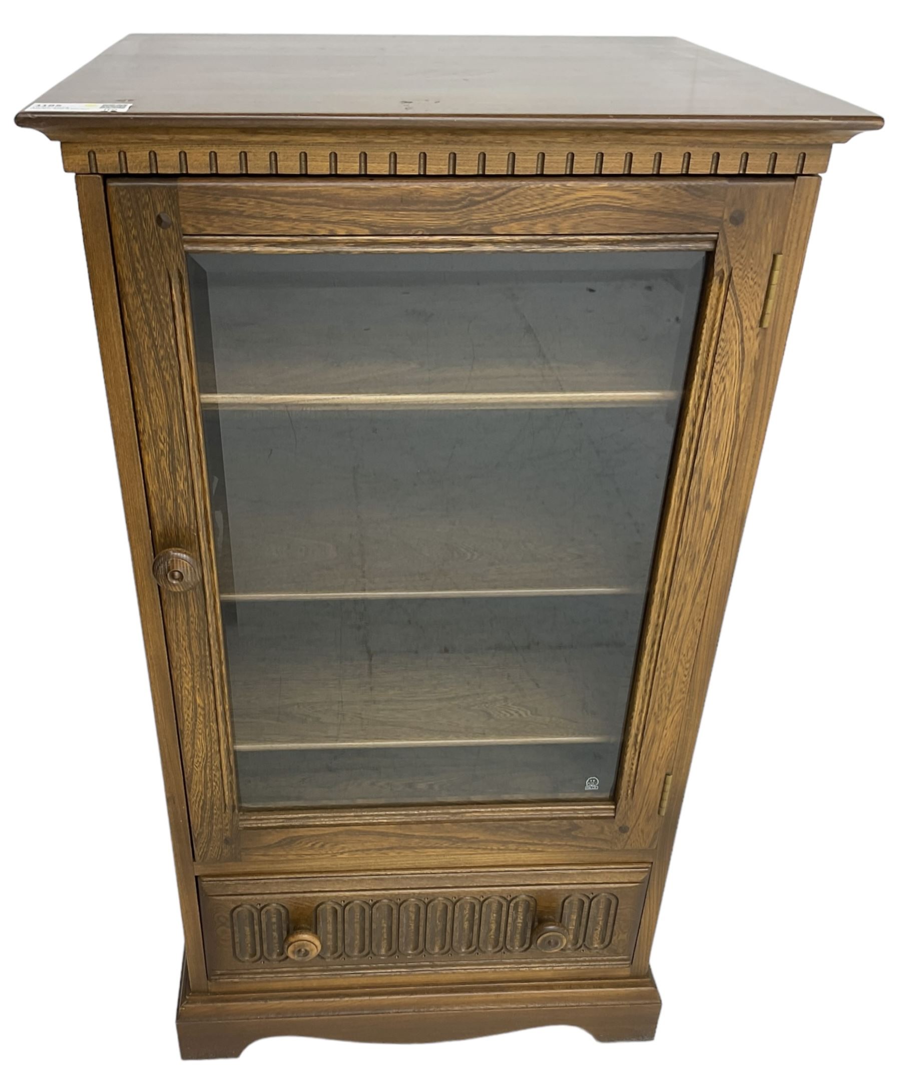 Ercol - mid-20th century dark elm 'Old Colonial' music cabinet, single glazed door enclosing three shelves, single drawer fitted to base