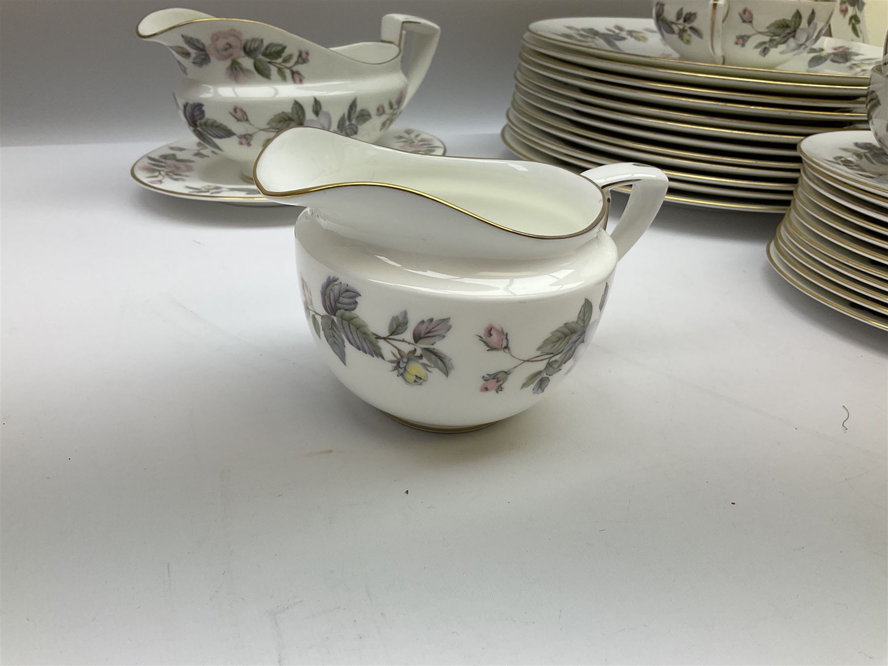 Royal Worcester June Garland pattern tea and dinner wares, comprising thirteen dinner plates, twelve dessert plates, twelve side plates, six twin handled soup bowls and six saucers, six small bowls, sauce boat and stand, thirteen teacups and fifteen saucers, open sucrier, and milk jug