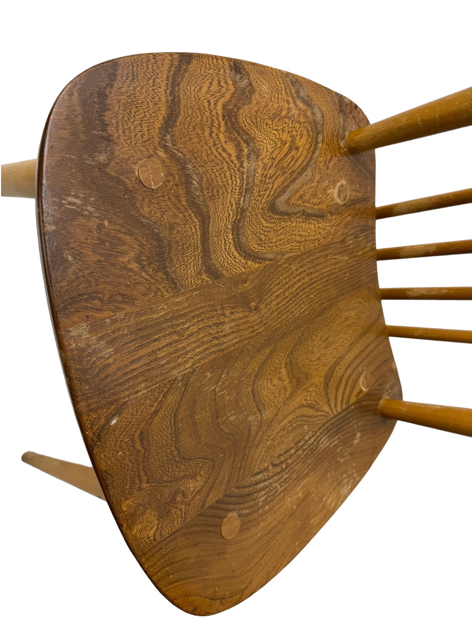 Ercol - pair of mid-20th century highback 'Windsor' chairs, curved top rail over six vertical spindles and shaped seat, on tapering cylindrical supports with stretchers