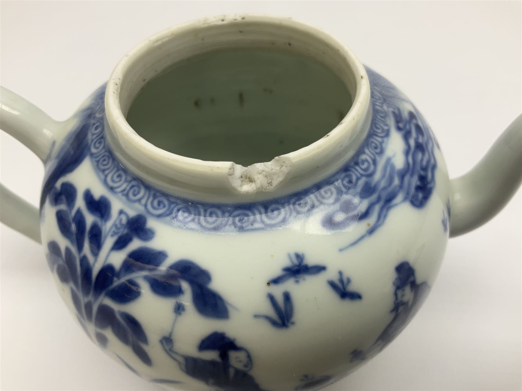 Two late 18th/early 19th century Chinese export teapots, the largest example of globular form with curved handle and straight spout, decorated in the Mandarin style with figural scenes surrounded by red scale reserves, H13.5cm, the second smaller example decorated in underglaze blue with two musicians in a landscape set with willow tree and fence, H10.5cm

