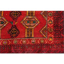 Persian Baluchi crimson ground rug, decorated with three columns of geomtric motifs