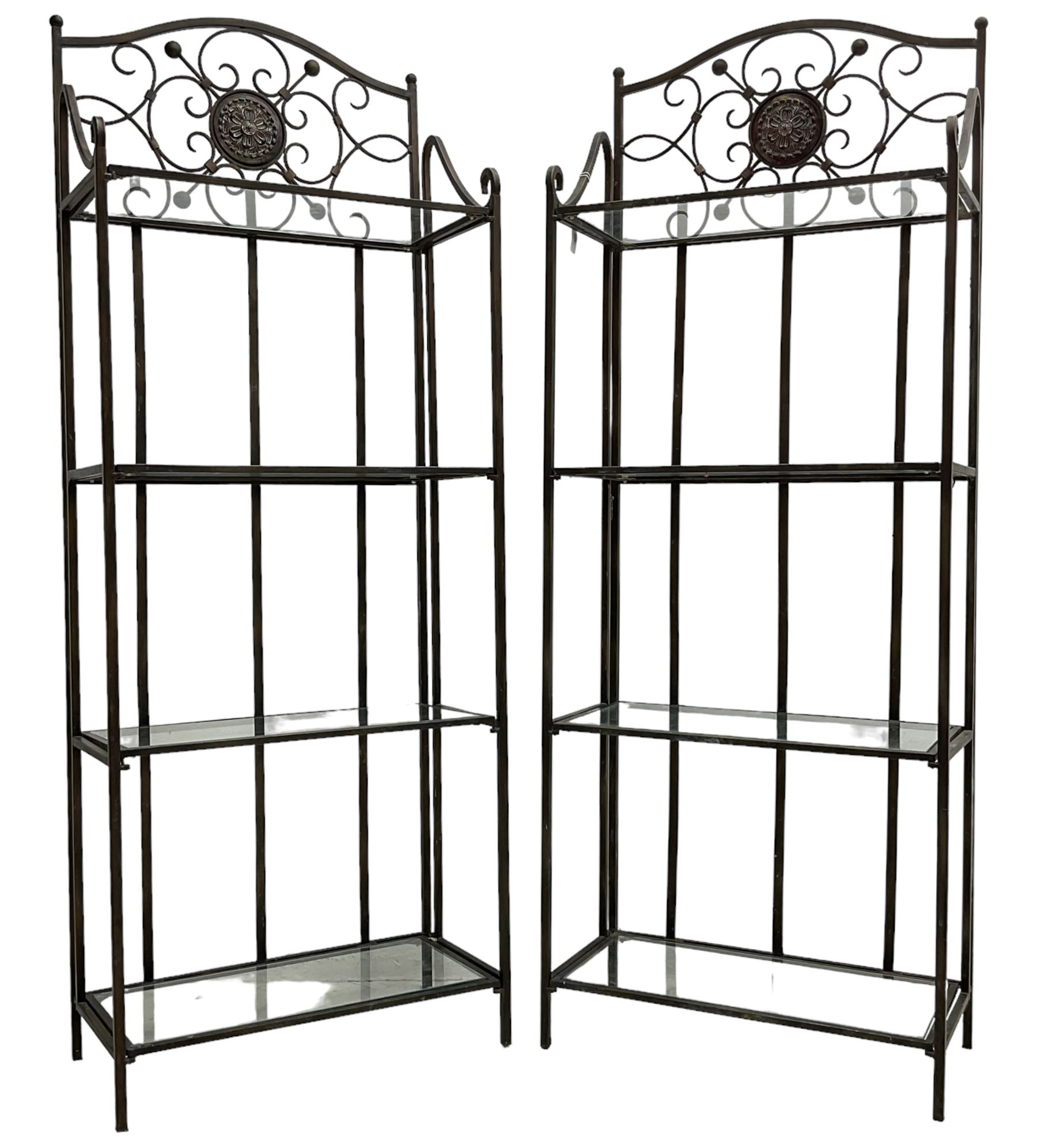 Pair of wrought metal conservatory plant stands, raised back with scrolling design, each fitted with three glass shelves