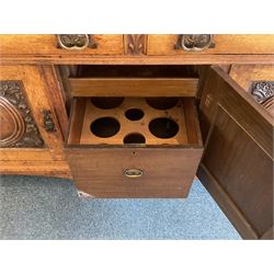 Late 19th century Arts & Crafts period oak mirror back sideboard, shaped bevelled mirror back carved with foliate scrolls and flower heads, down swept supports with elongated club-shaped uprights, moulded rectangular top over two drawers and three cupboards, the drawer fronts with copper handles decorated with sailing ships, panelled doors carved with mythical beasts, flowerheads and foliage, on moulded block feet