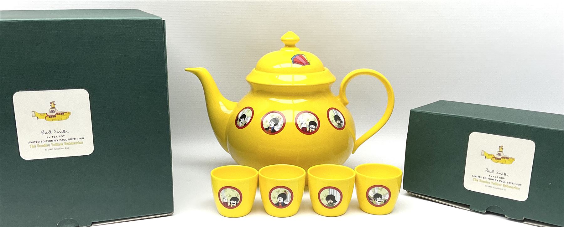 Limited edition Beatles Yellow Submarine teapot, designed by Paul Smith and made for Thomas Goode, 4/200, together with matching egg cups, 25/200, both in original boxes. 