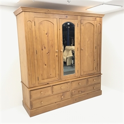  Large pine three door combination wardrobe, projecting cornice, three doors, single mirror above four short and two long drawers, plinth base, W206cm, H212cm, D62xm  